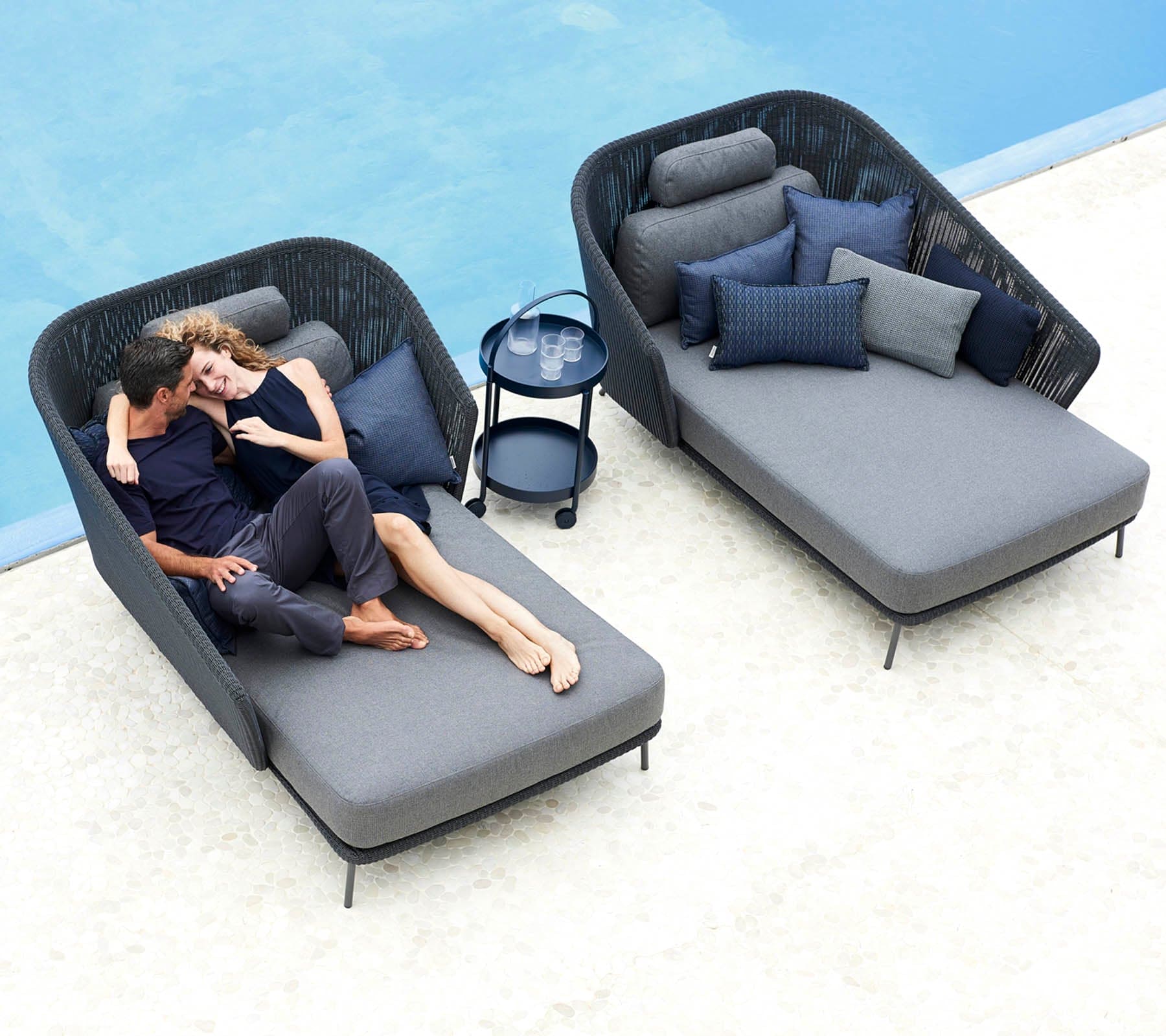 Boxhill's Mega Modern Outdoor Right Module Daybed lifestyle image with Mega Modern Outdoor Left Module Daybed and a couple sitting down showing affection beside the pool