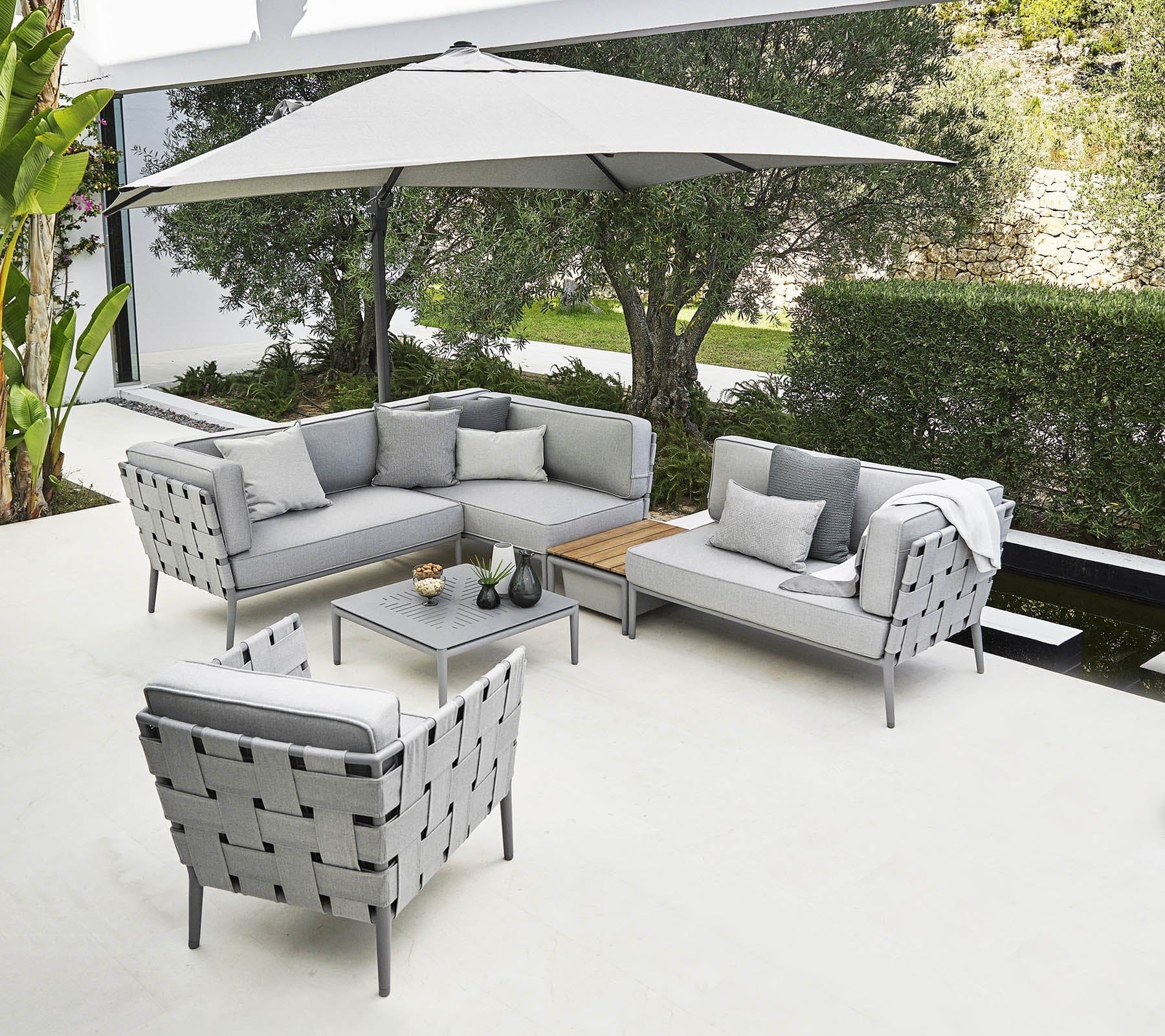 Boxhill's Conic 2-Seater Right Module Sofa Light Grey lifestyle image with big umbrella sunshade at patio
