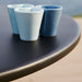 Boxhill's Area Outdoor Aluminum Dining Table Lava Grey close up view with 3 cups on top