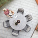 Boxhill's Ocean Outdoor Dining Armchair lifestyle image with round dining table and a man sitting down at patio, top view