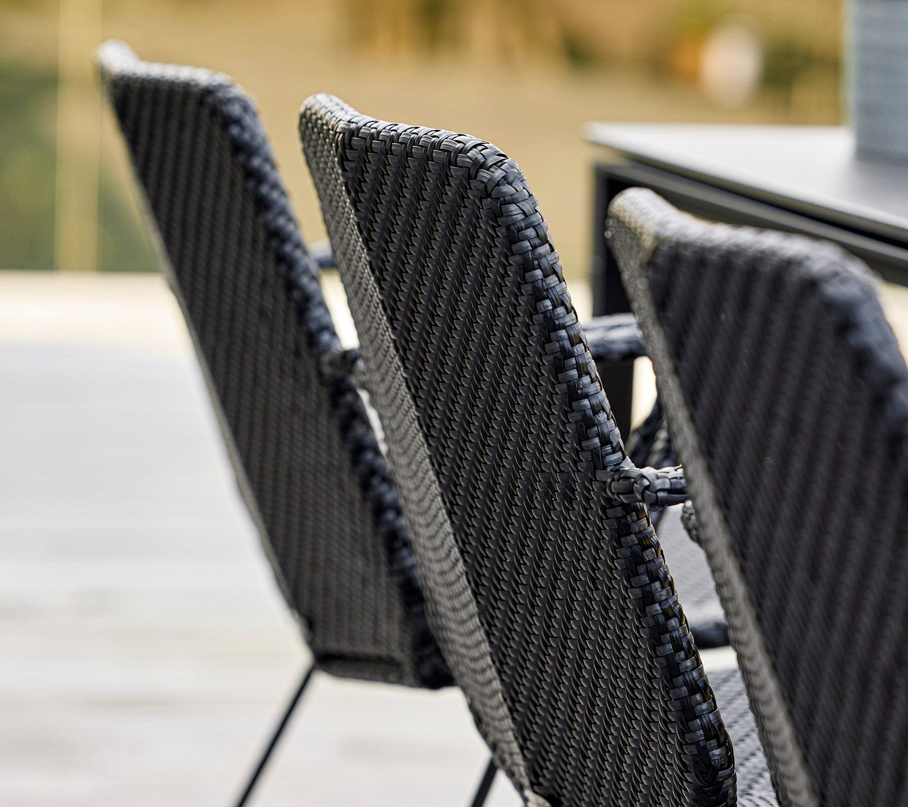 Boxhill's Vision black outdoor dining chair arranged in row beside dining table