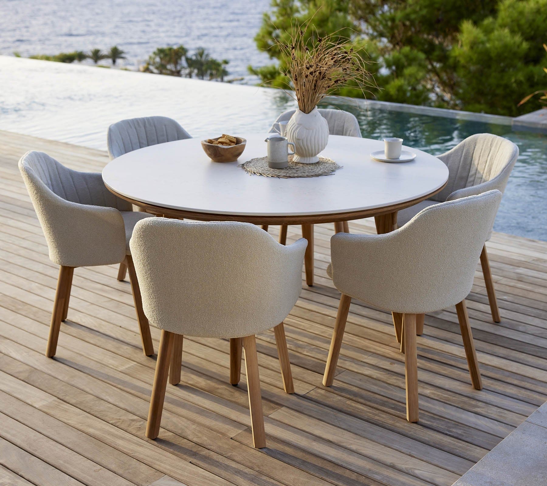 Boxhill's Choice Outdoor Dining Chair Teak Legs lifestyle image with Aspect Round Table beside the pool