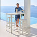 Boxhill's Cut High Outdoor Bar Table White lifestyle image with Cut High Outdoor Bar Chair and a woman standing beside the pool