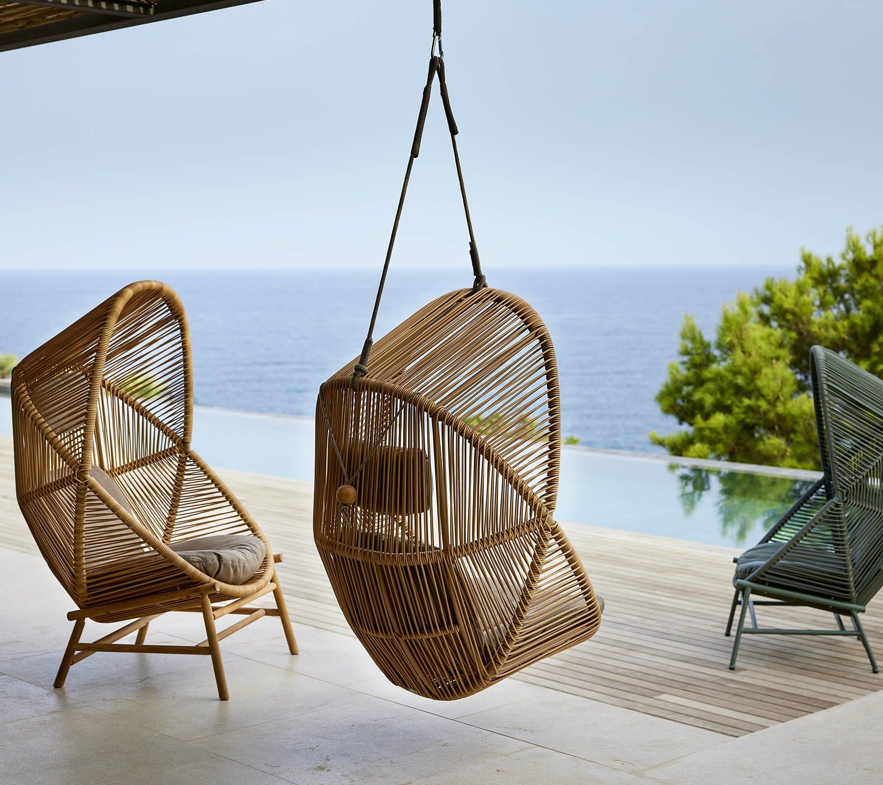 Boxhill's Hive Outdoor Hanging Chair Natural and Dusty Green Frame lifestyle image beside the pool