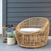 Boxhill's Nest Round Rattan Chair lifestyle image beside Lighthouse Outdoor Large Teak Lantern and a plant, at patio