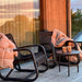 Boxhill's Curve Lounge Weave Outdoor Chair Graphite lifestyle image at patio with fabric cloth hanging on armrest and round side table with 2 cups on it