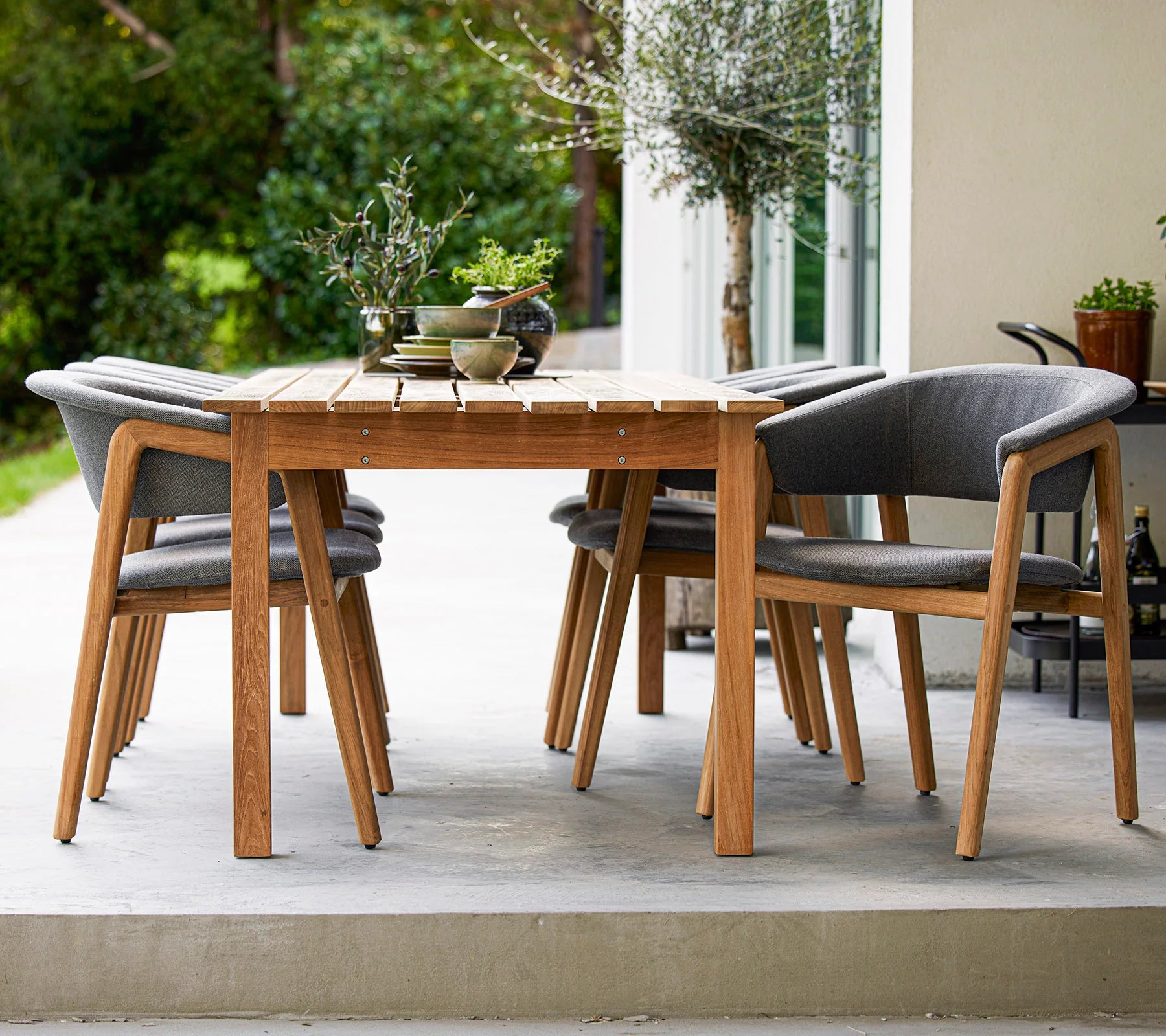 Boxhill's  Luna Outdoor Dining Armchair Lifestyle image with teak dining table