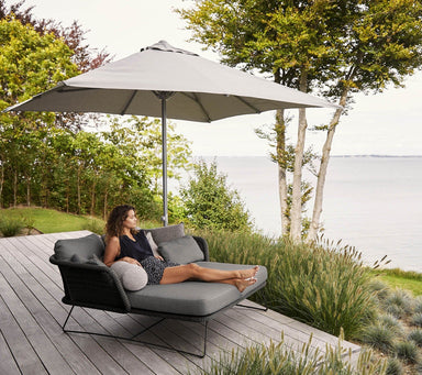 Boxhill's Major Parasol w/ Sliding System | 3x3 m lifestyle image with a woman sitting down on Horizon Outdoor Daybed
