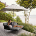 Boxhill's Major Parasol w/ Sliding System | 3x3 m lifestyle image with a woman sitting down on Horizon Outdoor Daybed