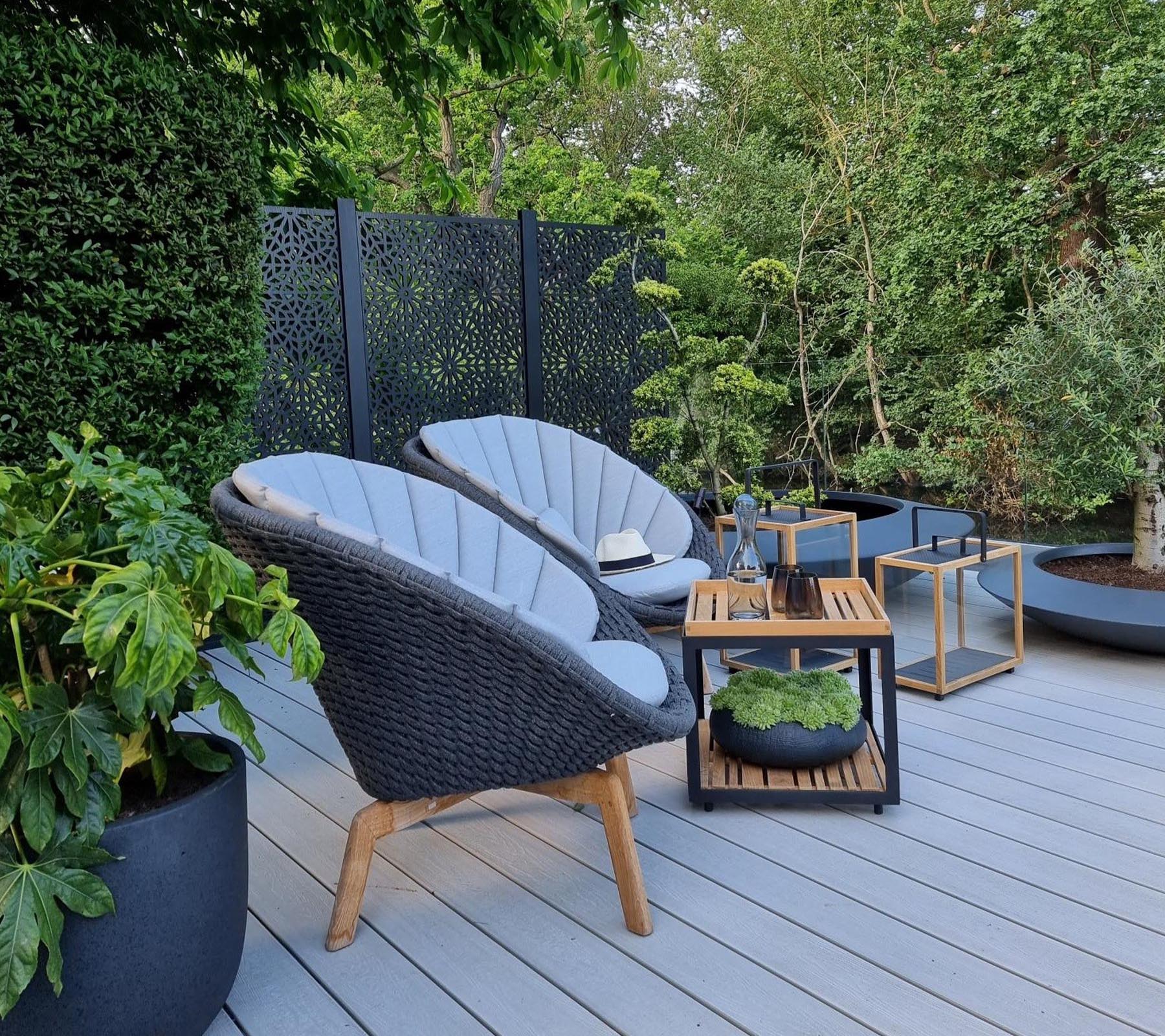 Boxhill's Peacock dark grey outdoor lounge chair with teak coffee table and teak outdoor lantern placed in patio