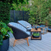 Boxhill's Peacock dark grey outdoor lounge chair with teak coffee table and teak outdoor lantern placed in patio