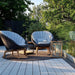 Boxhill's Peacock dark grey outdoor lounge chair with large teak outdoor lantern placed on brown outdoor rag