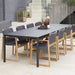 Boxhill's Pure dark grey aluminum outdoor dining table with teak dark grey dining chairs placed near the stairs