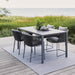 Boxhill's Pure grey aluminum outdoor dining table with grey outdoor dining chairs placed on wooden platform beside grass field