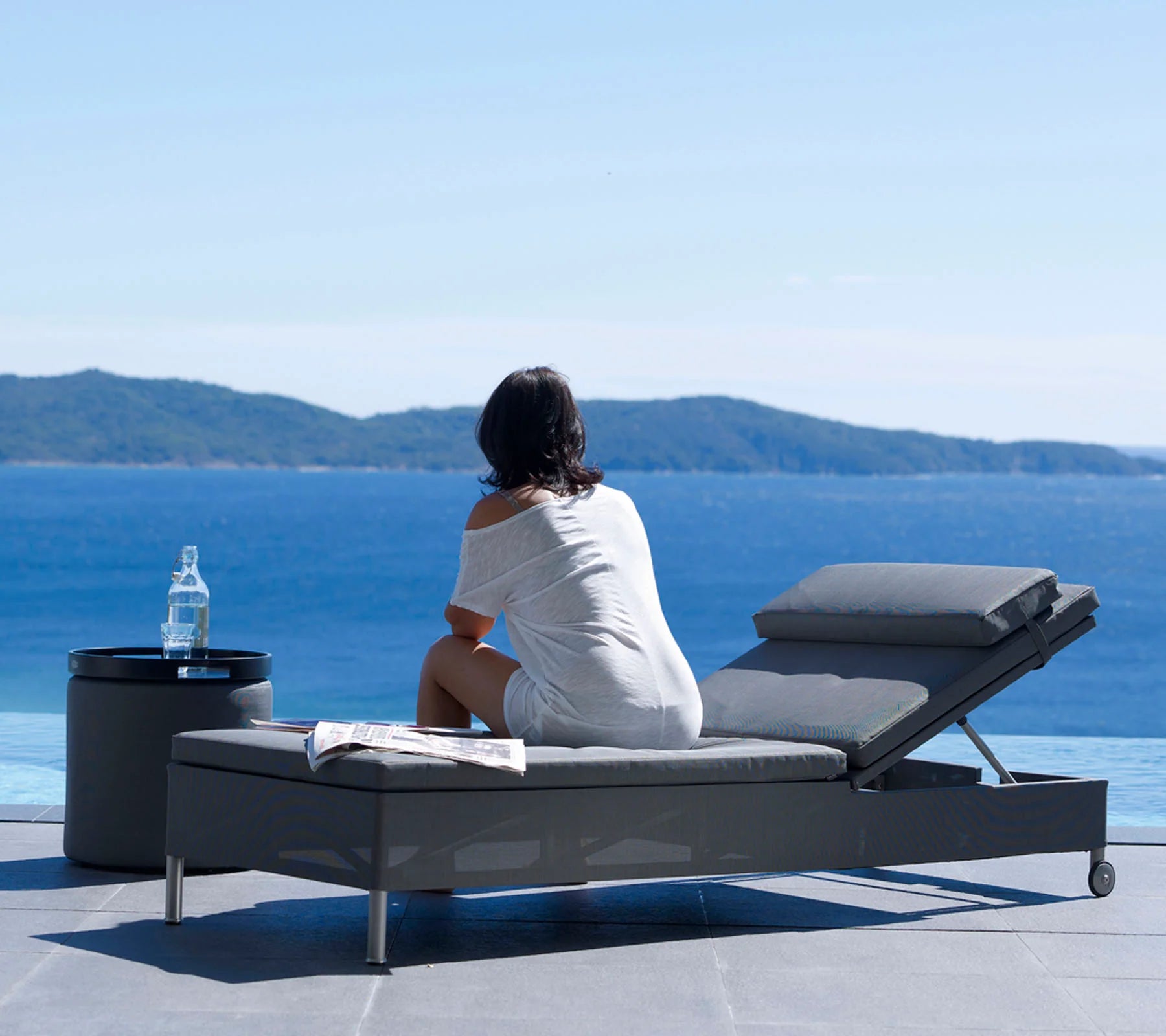  Boxhill's Rest grey outdoor chaise lounge | single sunbed placed beside the pool with a woman sitting on it