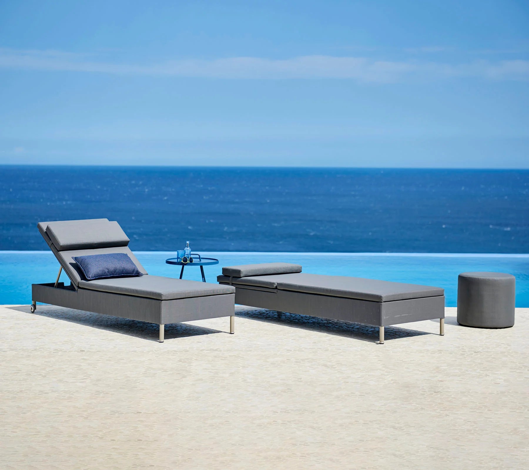  Boxhill's Rest grey outdoor chaise lounge | single sunbed with grey footstool and blue round side table set on poolside