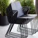 Boxhill's Vision black outdoor dining chair piled up with black round modern planter box placed in patio