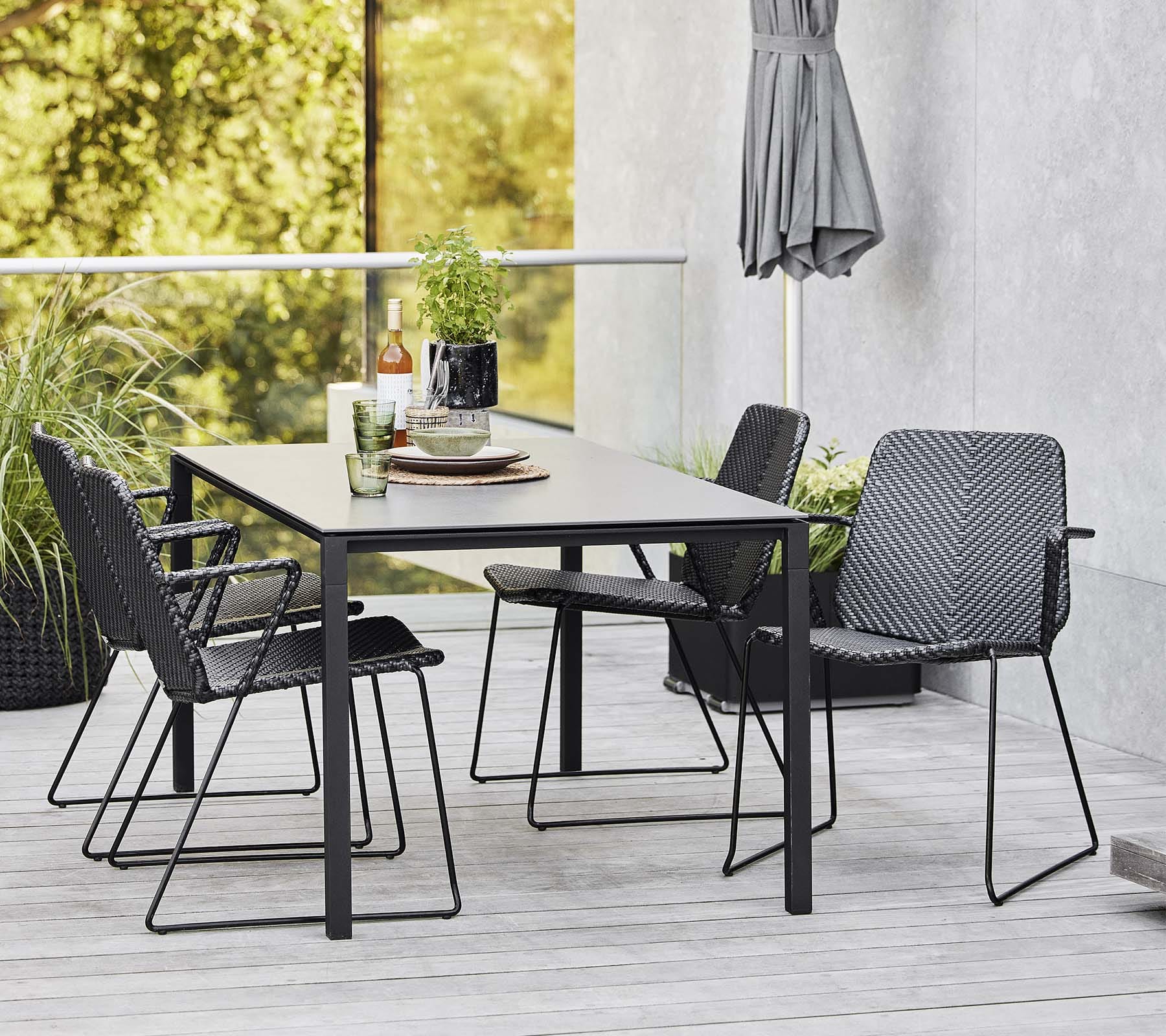 Boxhill's Vision black outdoor dining chair with dark grey outdoor dining table placed on balcony