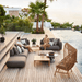 Boxhill's Capture Outdoor Coffee Table Lifestyle image with Capture Module Sofa beside the pool with man and a woman sitting down