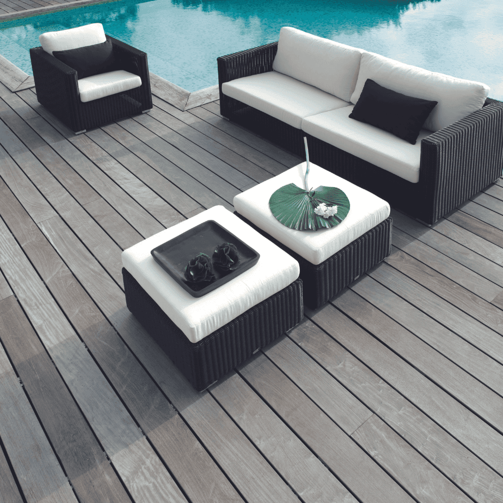 Boxhill's Chester Footstool, Weave Coffee Table lifestyle image with Chester 3-Seater Coastal Sofa and Chester Lounge Weave Coastal Chair on wooden platform poolside