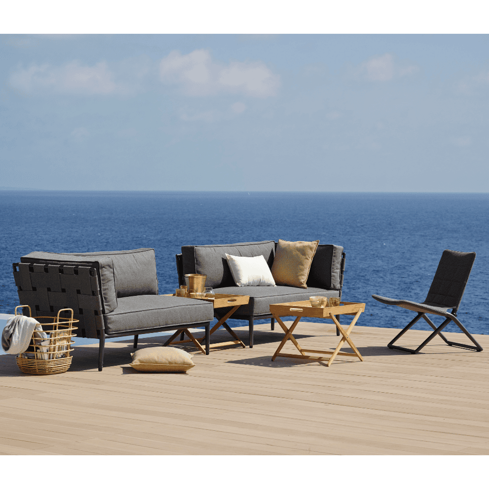 Boxhill's Conic 2-Seater Right Module Sofa Grey lifestyle image on wooden platform at seafront