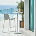 Boxhill's Go Outdoor Round Aluminum Bar Table White lifestyle image on balcony with glass and bottle of wine on top and bar chair at the side