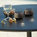 Boxhill's Go Outdoor Round Cafe Table Lava Grey Aluminum Top close up view with cups and glass of wine on top