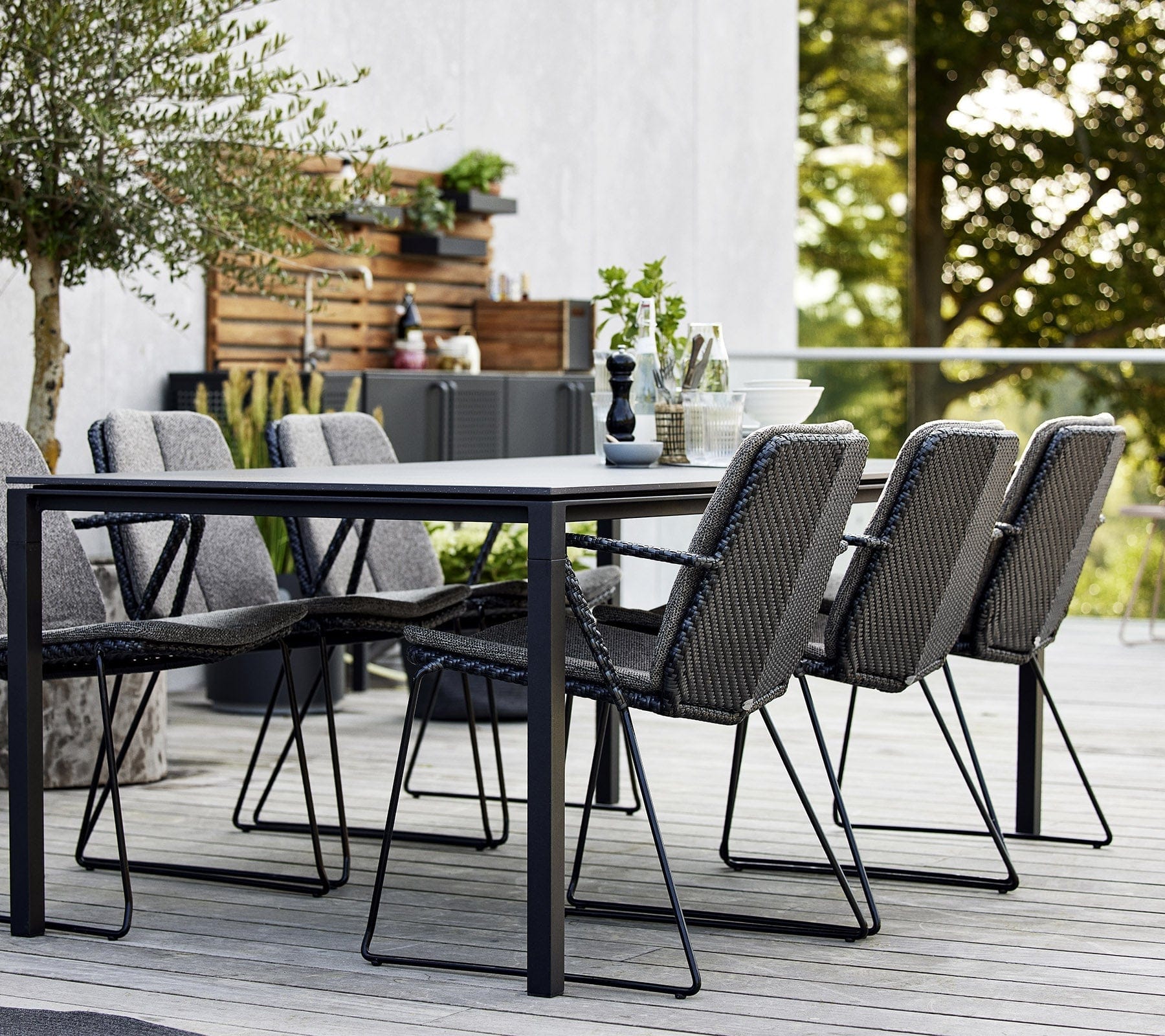 Boxhill's Vision black outdoor dining chair with dark grey cushion and dark grey outdoor dining table placed on balcony