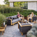 Boxhill's Angle 3-Seater Teak Frame Sofa lifestyle image with Angle Teak Frame Lounge Chair at the garden with man and woman sitting down