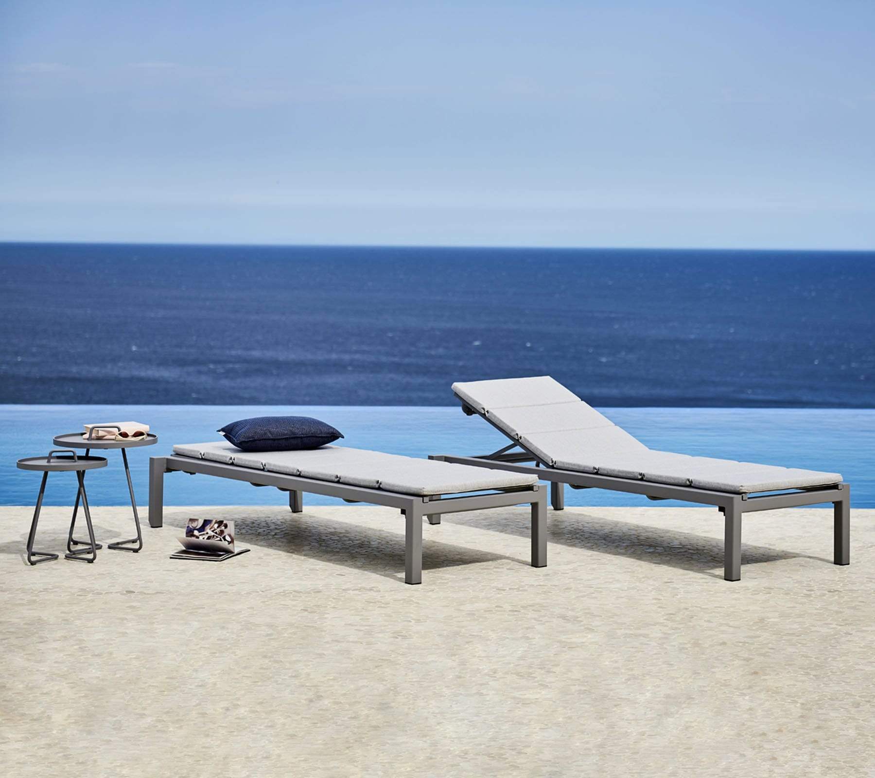 Boxhill's Relax light grey outdoor chaise lounge with 2 grey outdoor round side table set beside the pool