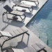 Boxhill's Siesta grey outdoor chaise lounge with grey outdoor round side table set beside the pool
