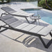 Boxhill's Siesta grey outdoor chaise lounge with grey outdoor round side table placed beside the pool