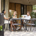 Boxhill's Noble Outdoor Dining Armchair lifestyle image at patio with 3 people sitting having a chat