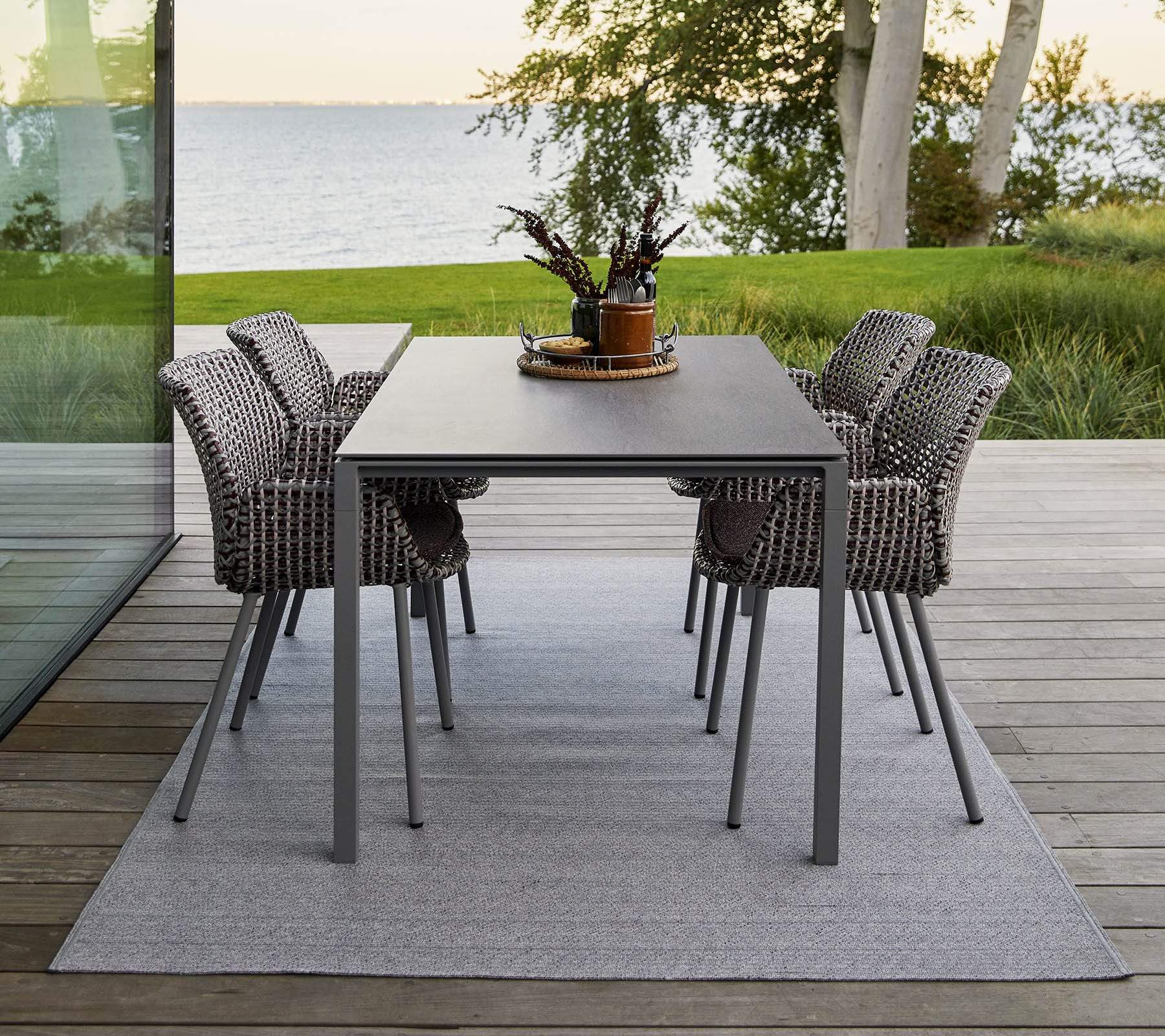 Boxhill's Vibe light grey / dusty rose outdoor armchair with grey rectangular outdoor dining table placed on wooden platform