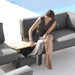 Boxhill's Conic Box Outdoor Storage Table lifestyle image in between Conic Module Sofa with a woman sitting down