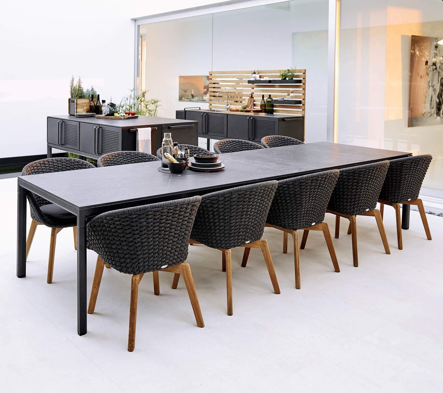 Boxhill's Drop Outdoor Dining Table with 78.8" Table Extension Lava Grey Base Black Tabletop lifestyle image with 10 dining chairs and Drop Outdoor Kitchen Module 