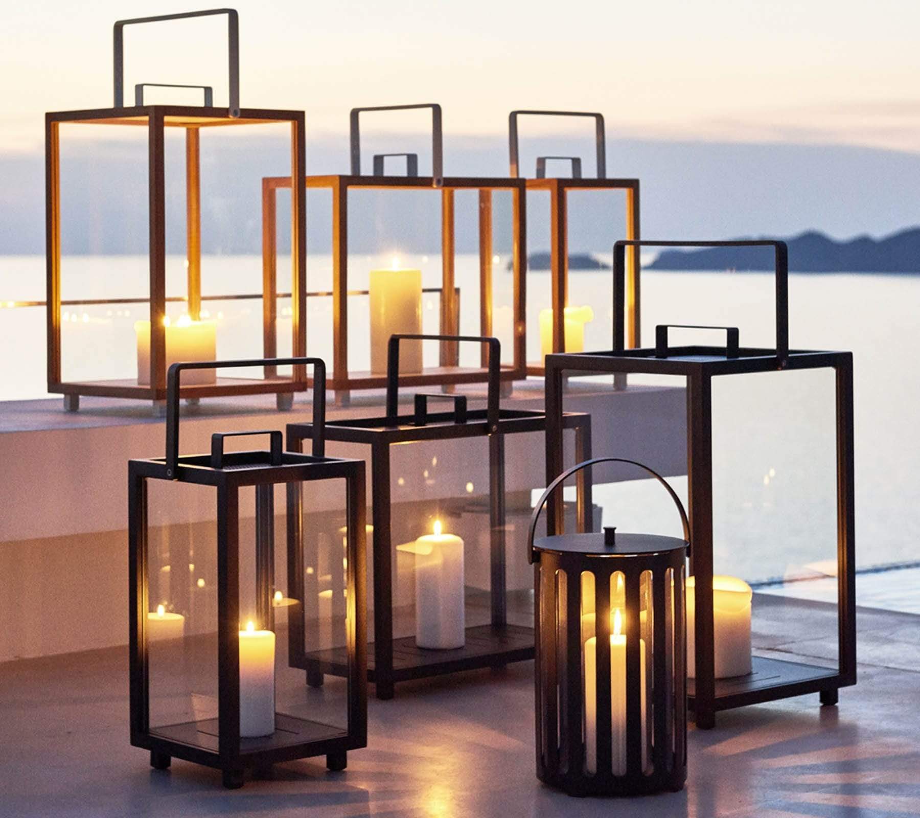Boxhill's Lighthouse Outdoor Large Teak Lantern for Candles | Set of 2 lifestyle image with Lighthouse Outdoor Large Aluminum Lantern and Lighttube Outdoor large Lantern at seafront