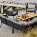 Boxhill's Ocean Outdoor Lounge Chair lifestyle image with Ocean Module Sofa and Level Coffee Table with Teak Top on wooden platform beside seashore