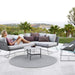Boxhill's Circle Outdoor Rug Grey lifestyle image with 2 seater sofa and chaise lounge with a woman sitting down beside the pool