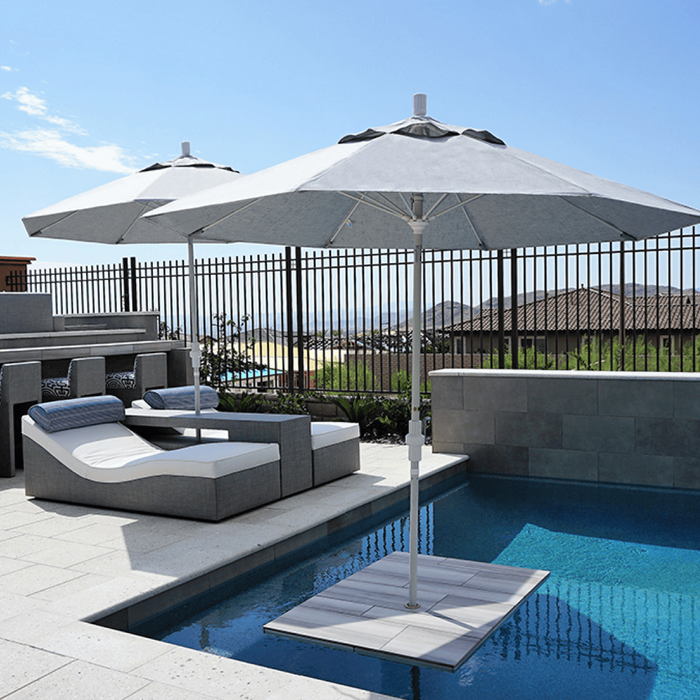 Two parasol outdoor umbrellas shade a pool lounge area.