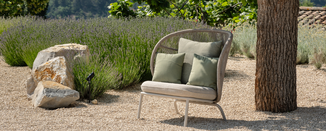 Outdoor lounge with aluminum frame and polypropylene rope has a grey cushion and sage green pillows