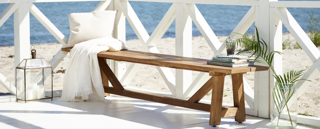 Wooden bench with white pillow by the sea shore