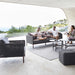 Boxhill's Encore 3-Seater Sofa lifestyle image at patio with Encore 2-Seater Outdoor Grey Sofa, Encore Outdoor Single Seater Grey Sofa and Cube Outdoor Footstool with 3 people sitting down