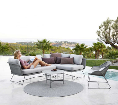 Boxhill's Horizon 2-Seater Outdoor Right Module Sofa lifestyle image at poolside with a woman lying down reading a magazine