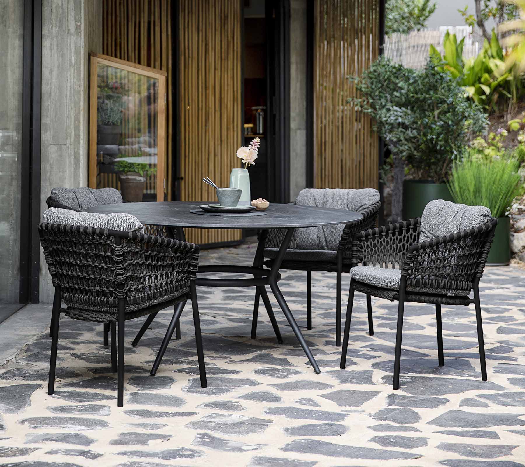 Boxhill's Ocean Outdoor Dining Armchair lifestyle image with round dining table at patio