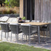 Boxhill's Ocean Outdoor Dining Armchair lifestyle image with dining table teak table top at patio
