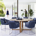 Endless Outdoor Round Dining TableBoxhill's Endless Outdoor Round Dining Table lifestyle image with cups and bowls on top, and 6 blue dining chairs at patio