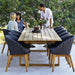 Boxhill's Endless Outdoor Rectangular Dining Table lifestyle image with dining chairs and 3 people having a chat
