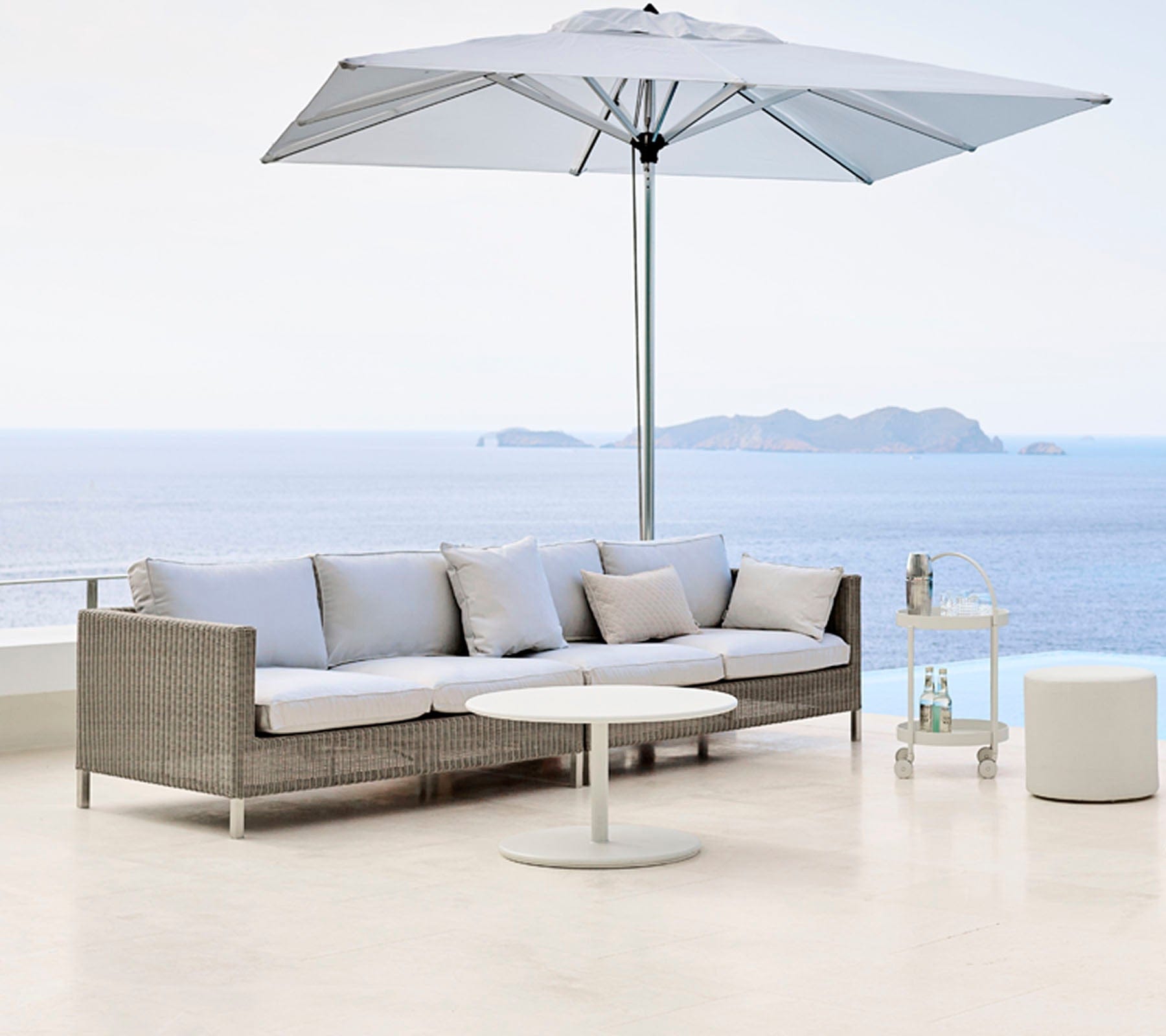 Boxhill's Connect 2-Seater Left Module Sofa lifestyle image with Connect 2-Seater Right Module Sofa with a big umbrella sunshade at seafront