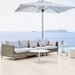Boxhill's Connect 2-Seater Left Module Sofa lifestyle image with Connect 2-Seater Right Module Sofa with a big umbrella sunshade at seafront